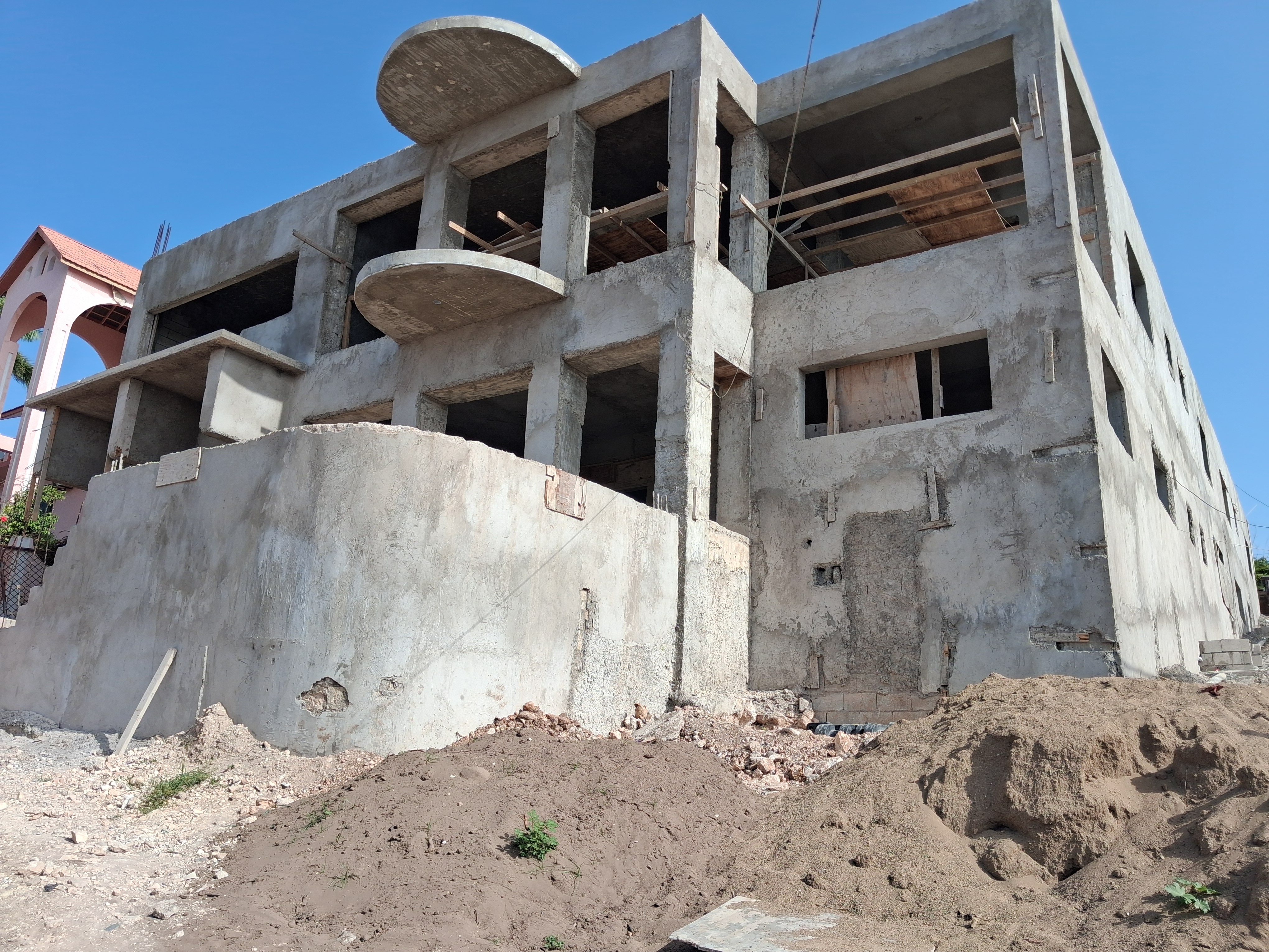 Client construction site — concrete structure with balconies, under construction